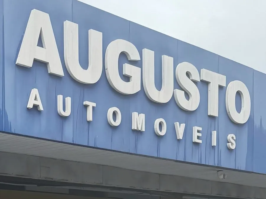 Letreiro azul da Augusto Automóveis na fachada da loja